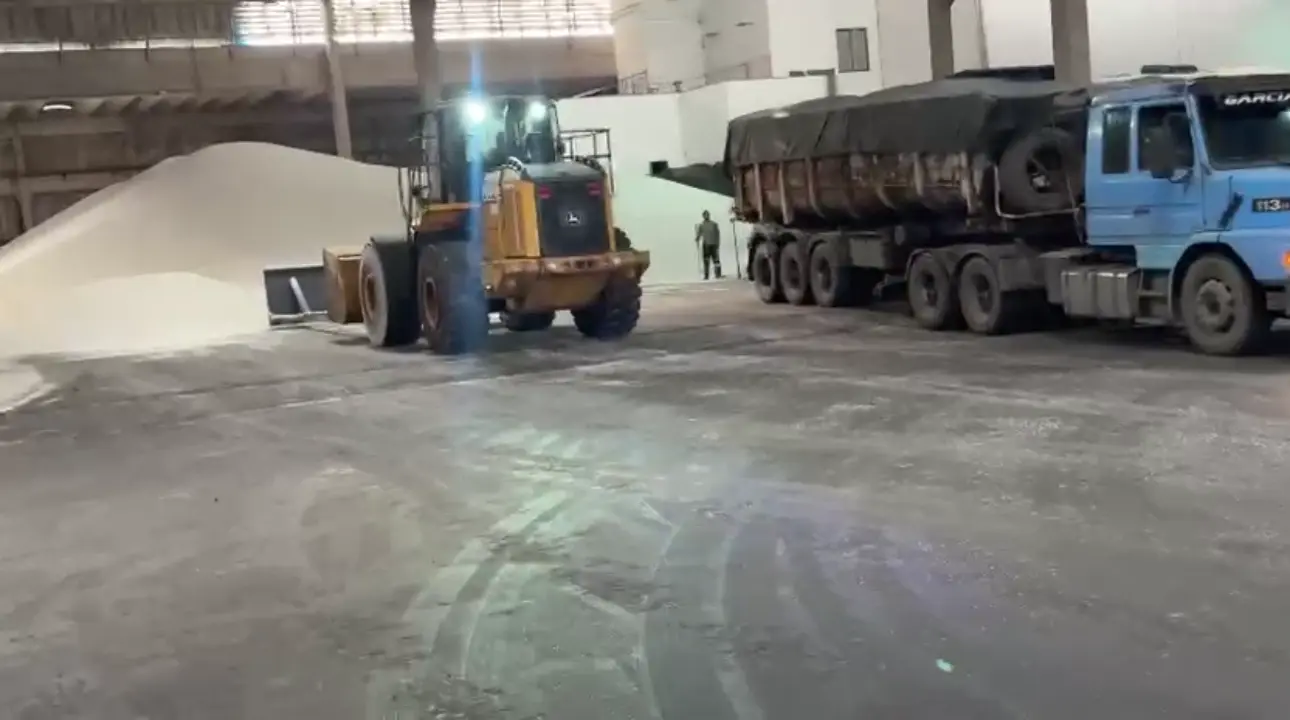Vídeo da pá carregadeira John Deere 724 carregando caminhões no interior de um armazém